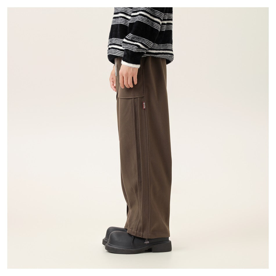 Side view of a model wearing loose brown cargo pants with a side pocket and long seam detail.