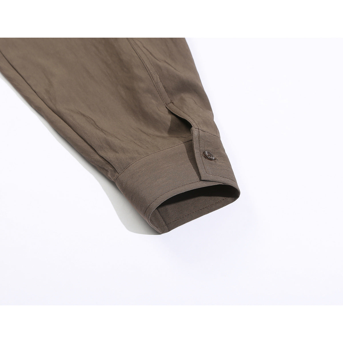 Close-up of the brown shirt's long sleeve and buttoned cuff.