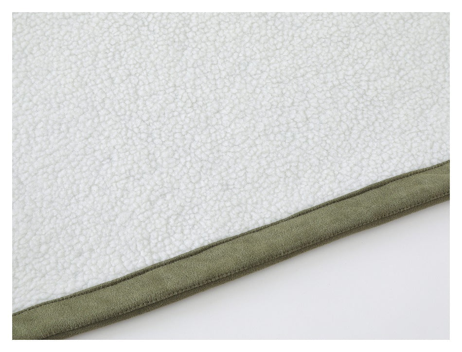 Close-up of white textured fleece bordered by olive-green trim.