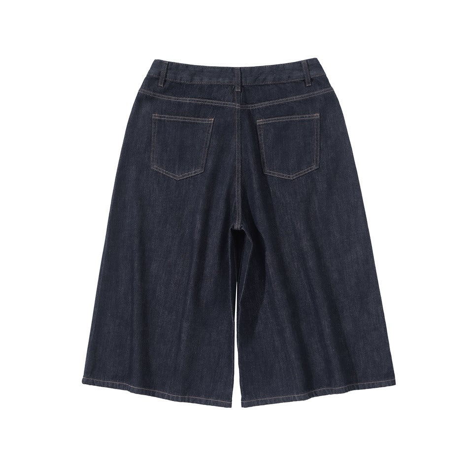 Back view of dark indigo wide-leg cropped jeans with two patch pockets and contrast stitching.