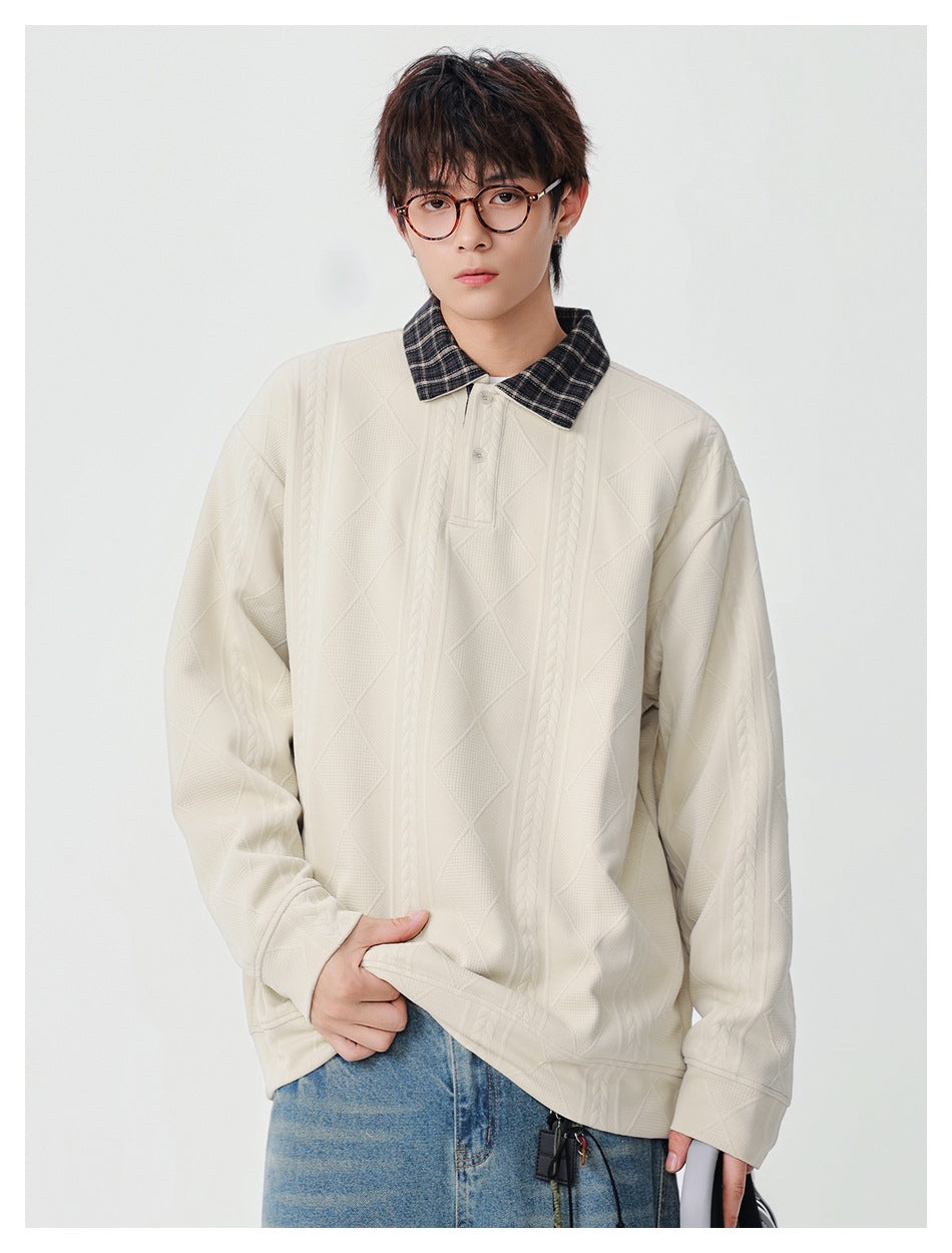 Model wearing off-white cable and diamond textured pullover with plaid collar, hand at hem, with jeans