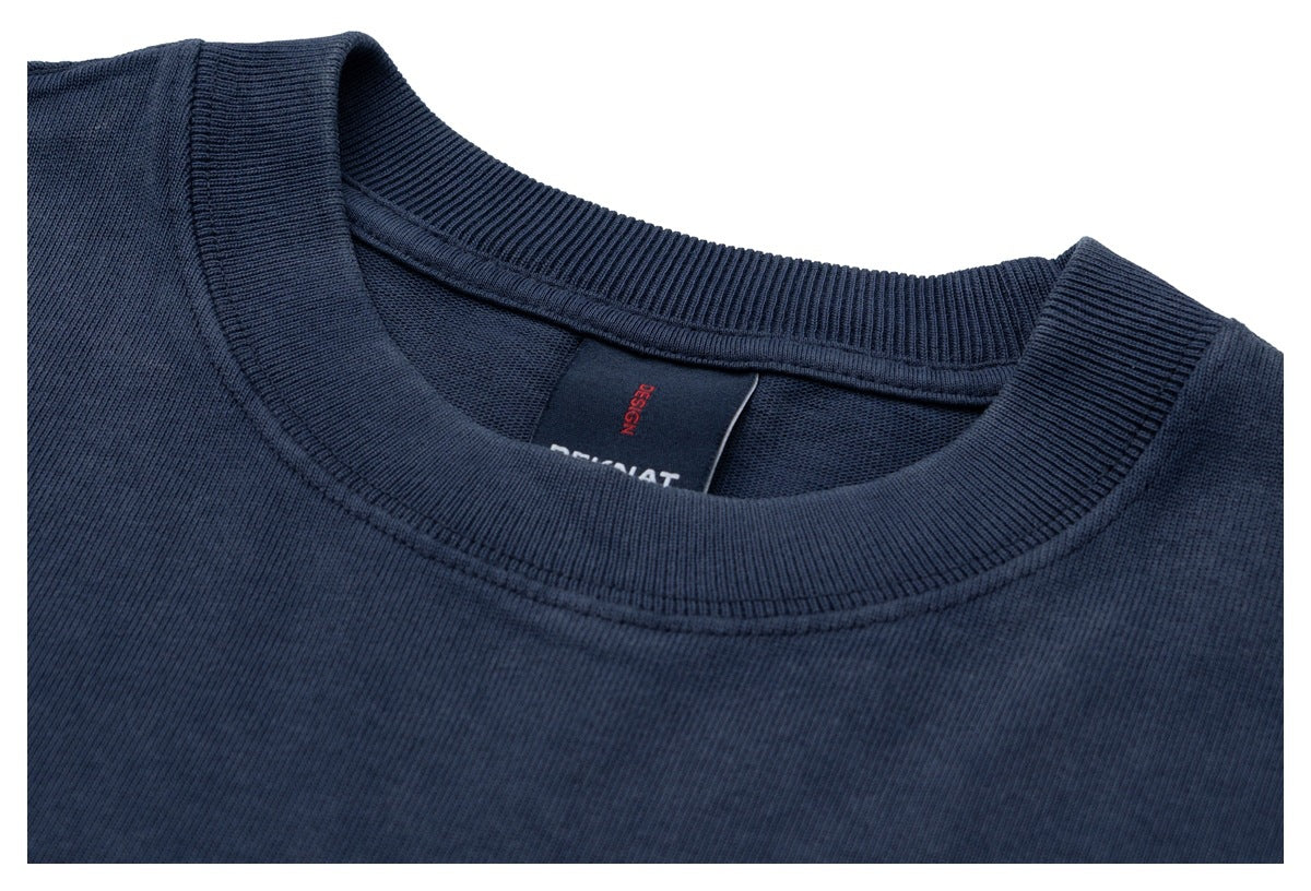 Close-up of the dark navy T-shirt's ribbed crew neckline and inside neck label.