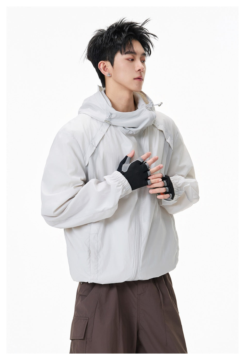 Close view of a model wearing a white hooded windbreaker with a high collar and front zipper.