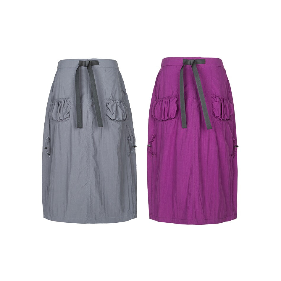 Rear view of gray and purple midi skirts with gathered pockets, adjustable waist straps, and side drawcords.