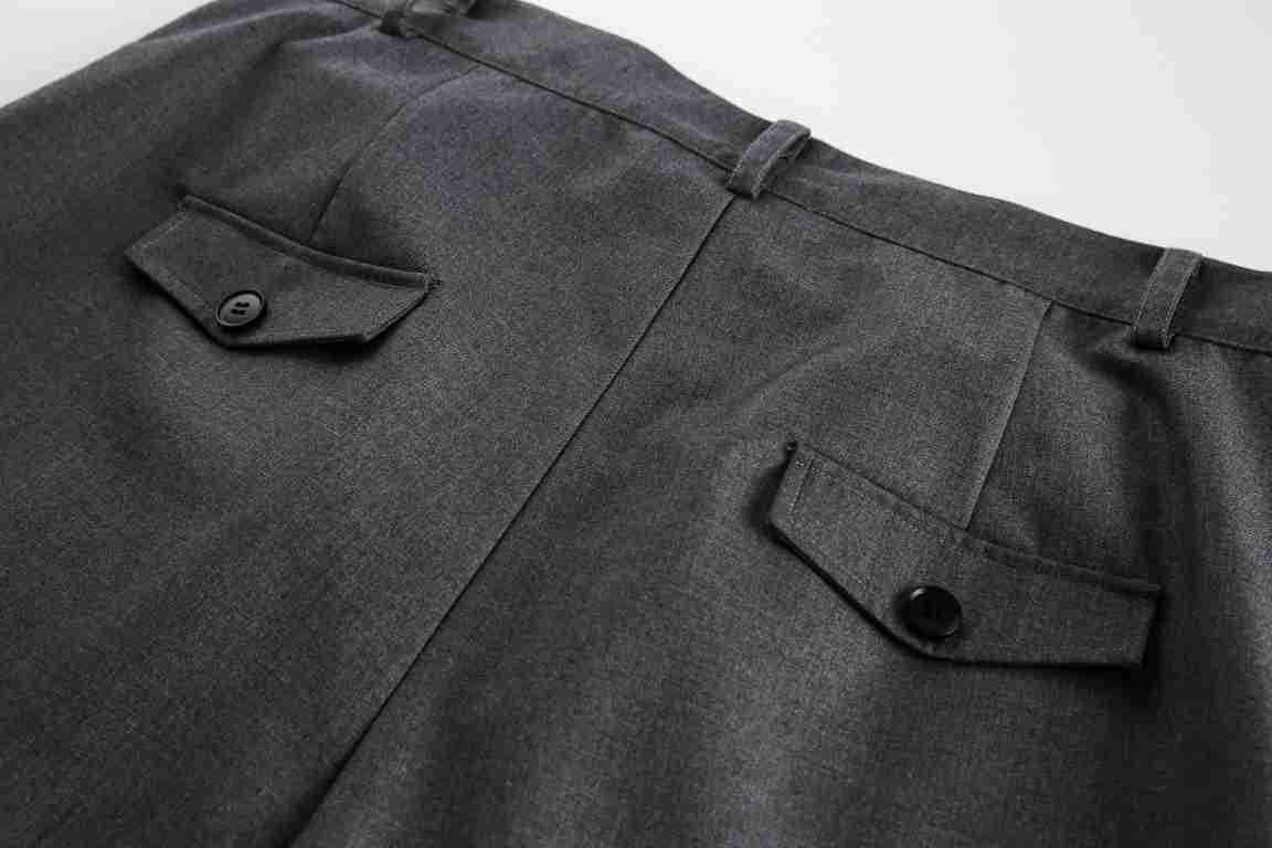 Close-up of the back of charcoal gray trousers, showing two buttoned flap pockets and belt loops.