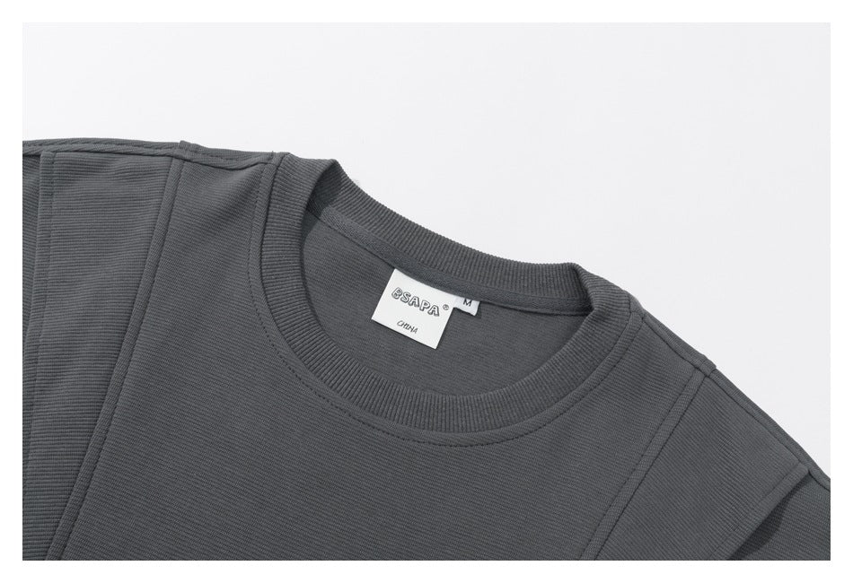 Close-up of a charcoal gray sweatshirt's ribbed crew neck, shoulder seams, and sewn neck label.