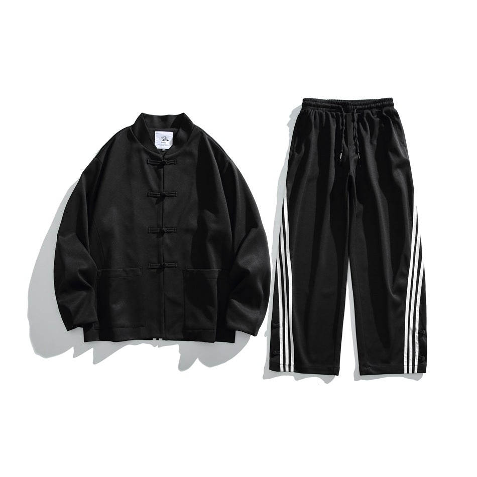 Flat lay of a black frog-button jacket and matching drawstring pants with white side stripes.