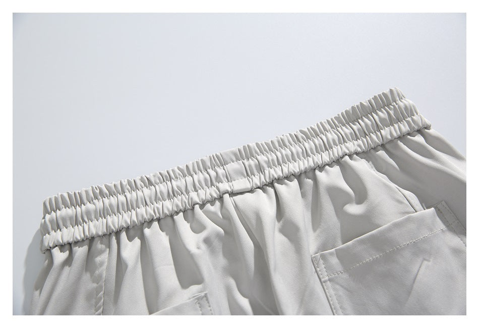 Close-up of the gathered back waistband and pockets on light gray shorts.