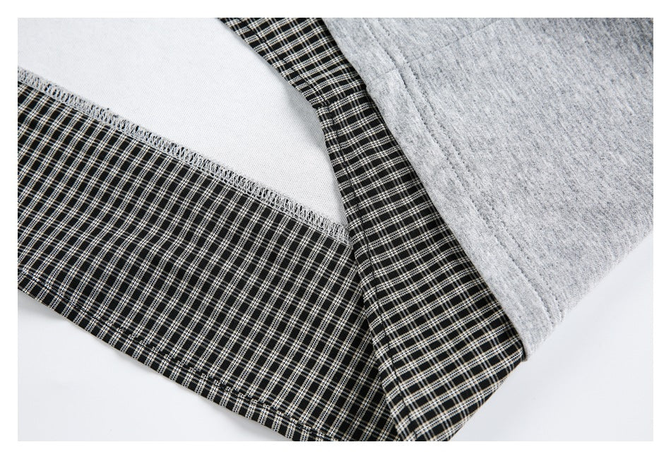 Close-up of checked fabric joined to heather gray fabric, showing the seam and white inner layer.