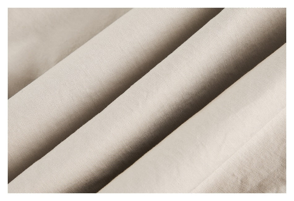 Extreme close-up of beige fabric folds showing a fine diagonal weave.