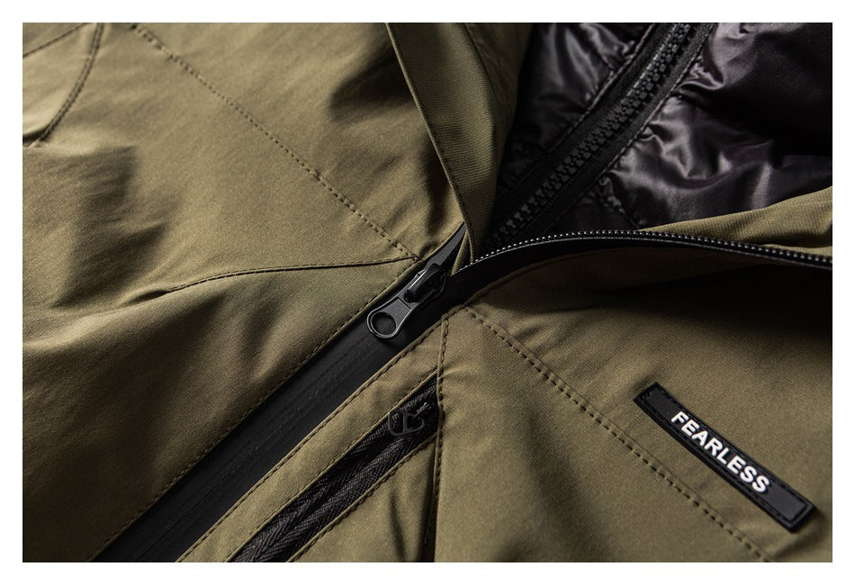 Close-up of an olive jacket's black front zipper, inner lining, and FEARLESS fabric badge.