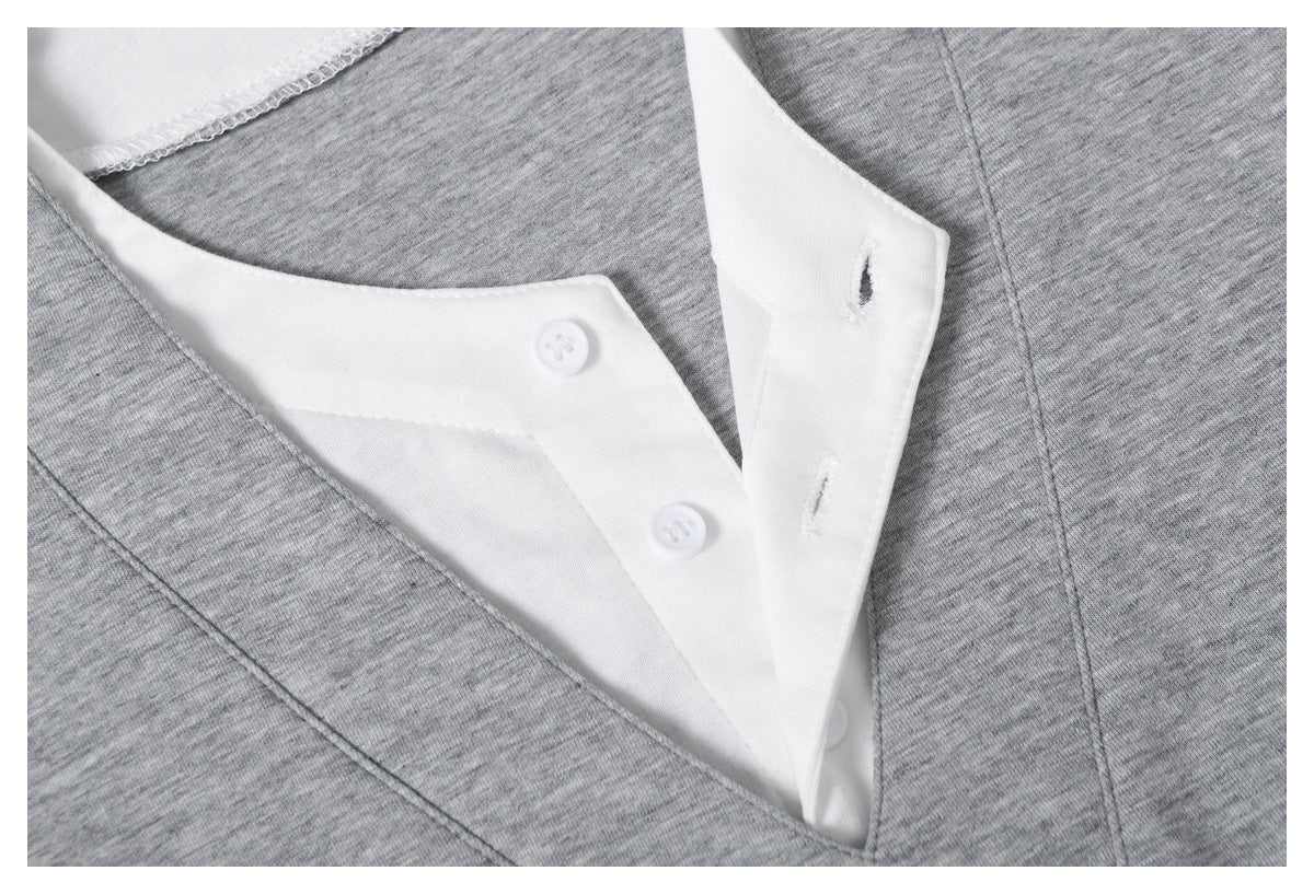 Close-up of the gray top's white button placket, buttonholes, and layered V-neck opening.