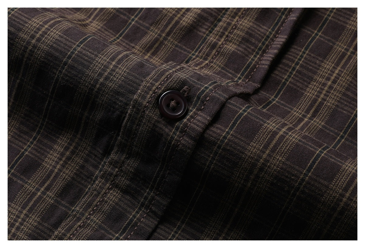 Close-up of the button placket and stitching on a dark brown plaid shirt.