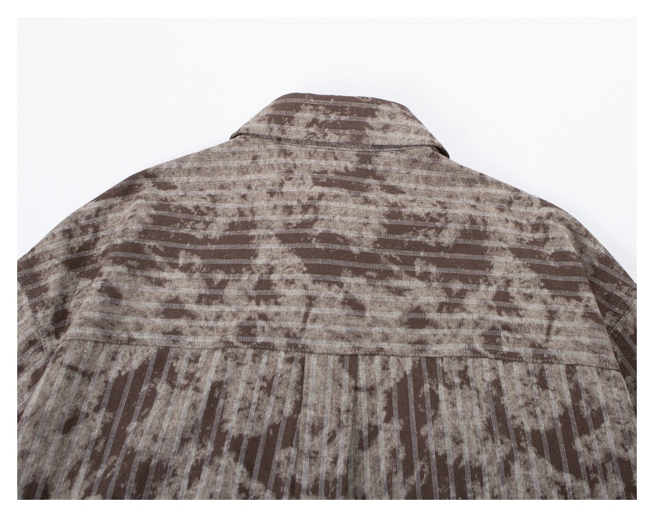 Upper back of a brown and beige patterned button-up shirt, showing the collar and horizontal yoke.