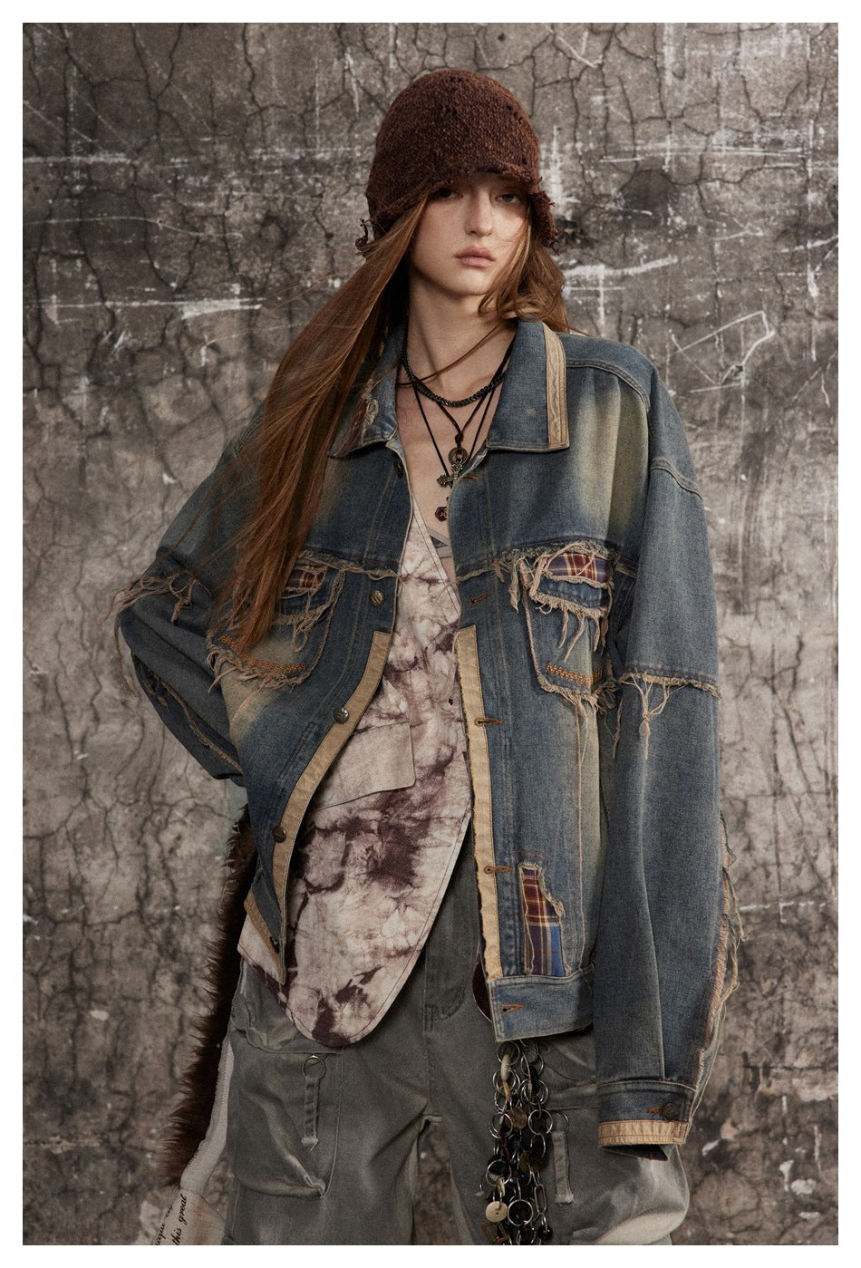 Model wearing oversized washed denim jacket with frayed plaid pockets over a tie-dye top and cargo pants