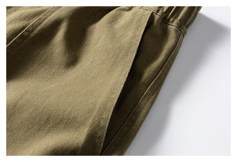 Close-up of a khaki trouser side pocket and stitched side seam.