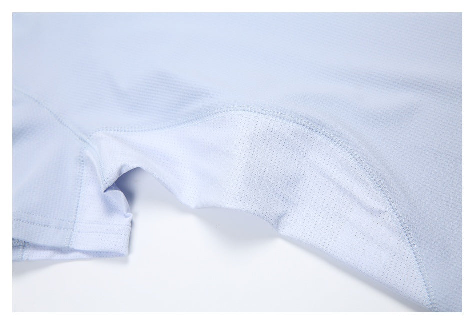 Close-up of a light blue shirt's perforated underarm panel and curved seam.