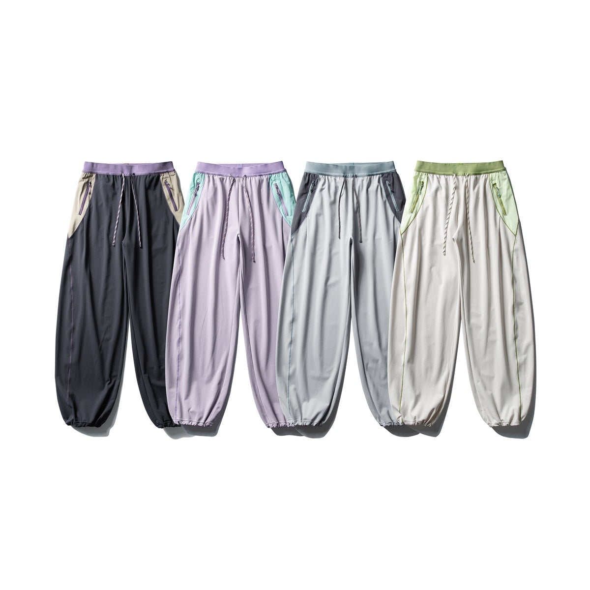 Four colorways of loose jogger pants with contrast waistbands, side panels, drawstrings, and ankle cuffs.