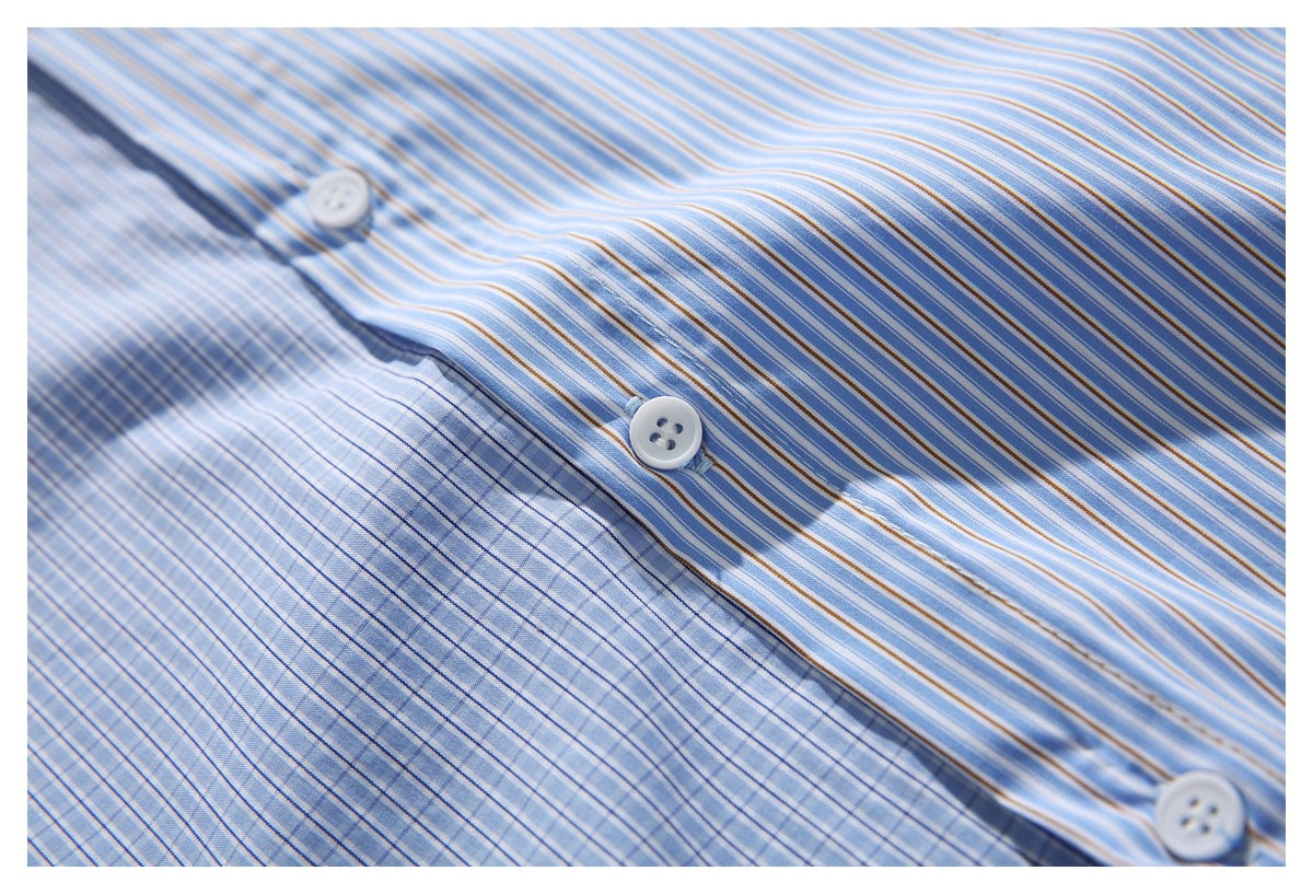 Close-up of white buttons and placket on a blue, white, and tan striped shirt.