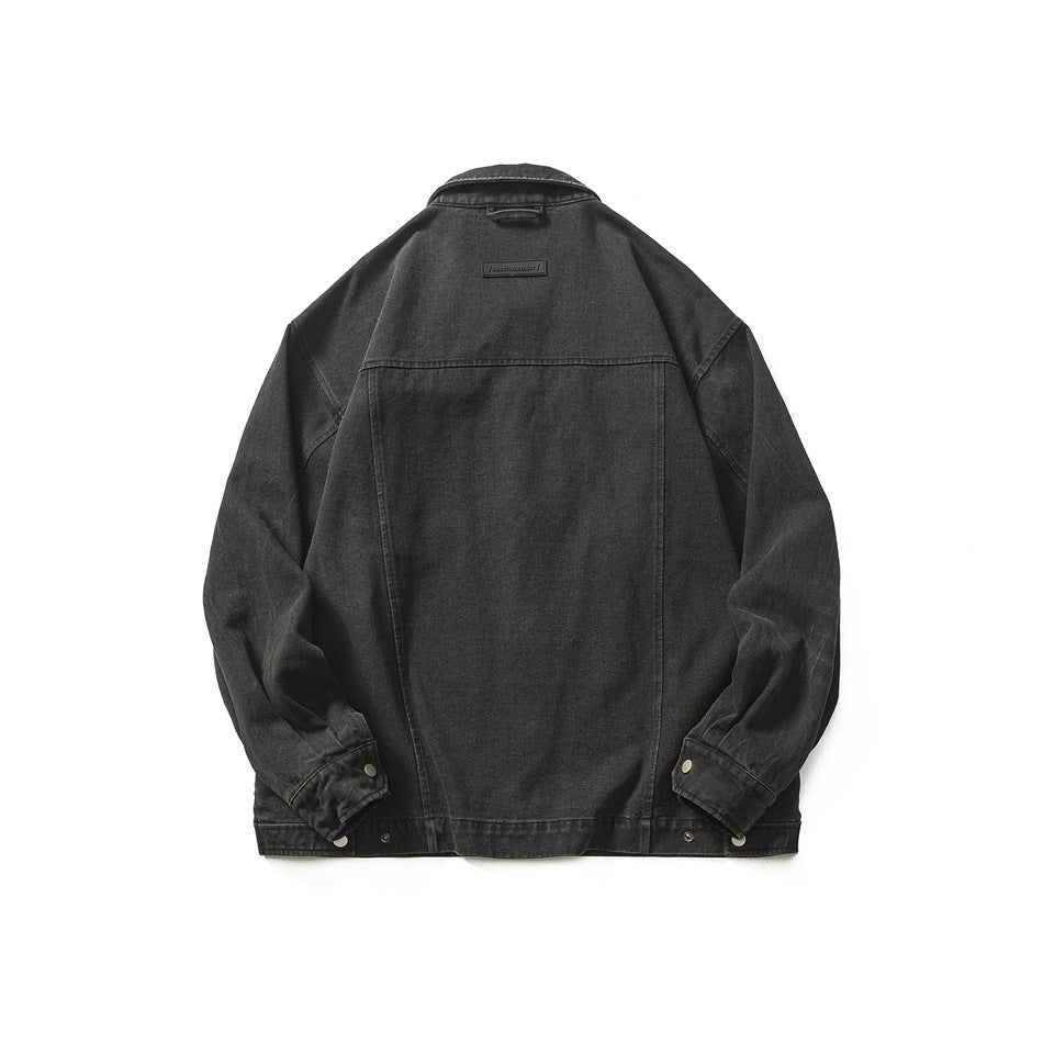 Back view of black washed denim-style jacket with yoke seam, small back label and snap cuffs