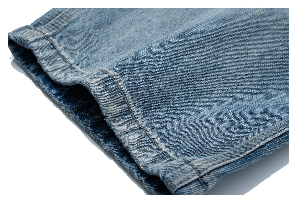 Close-up of the stitched, folded hem of blue denim jeans.
