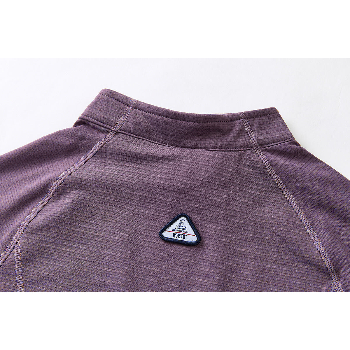 Close-up of the purple jacket's back collar, raglan seams, and small triangular patch.