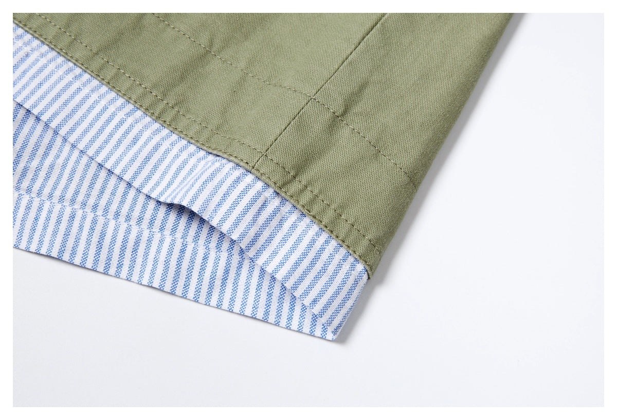 Close-up of an olive-green shirt hem with blue-and-white striped fabric visible along the inside edge.