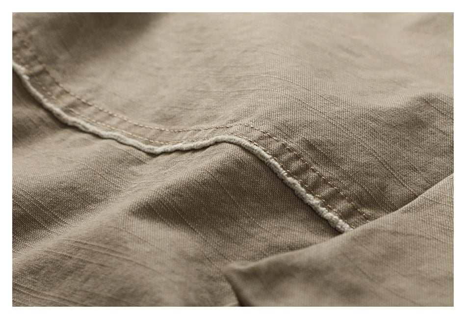 Close-up of khaki fabric with a curved double-stitched seam.