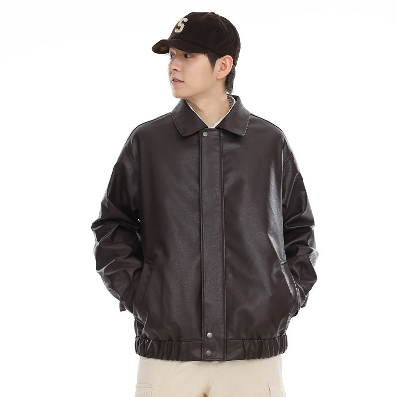 Front view of a model wearing a dark brown collared jacket with a snap-front placket, angled pockets and elastic hem.