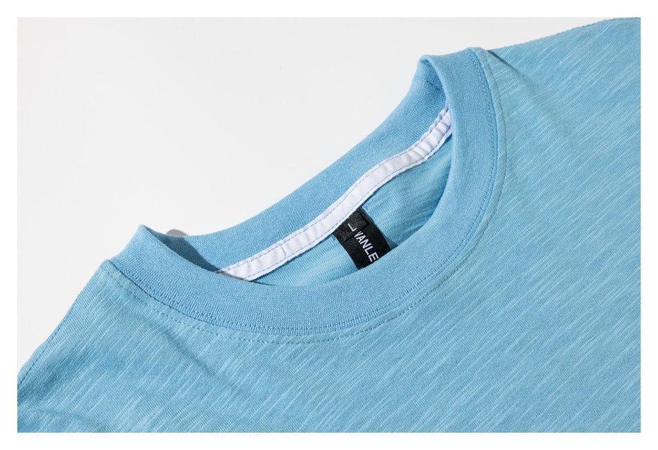 Close-up of a light blue shirt’s ribbed crew neckline and sewn-in label.