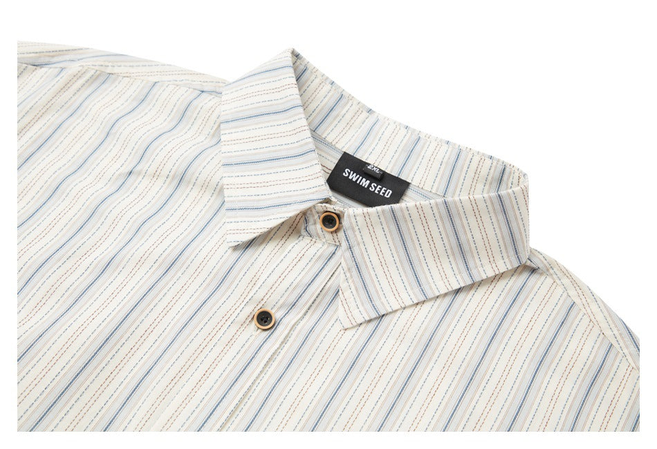 Upper portion of an ivory striped button-up shirt, showing its collar, buttons, and neck label.