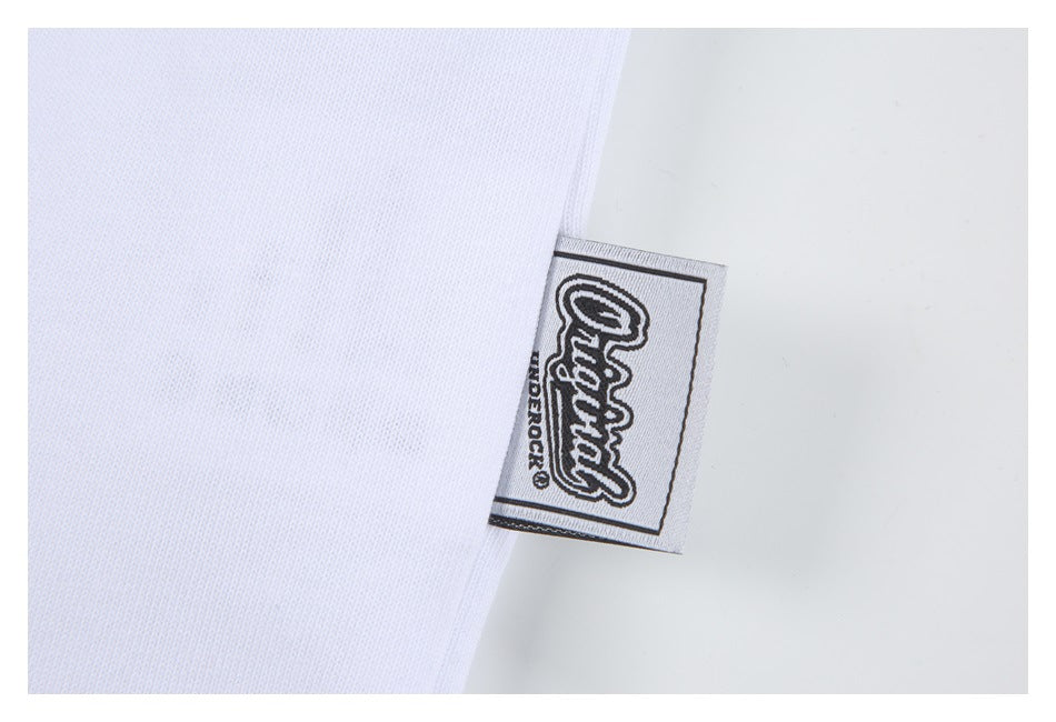 Close-up of a black-and-white woven label sewn into the edge of white T-shirt fabric.