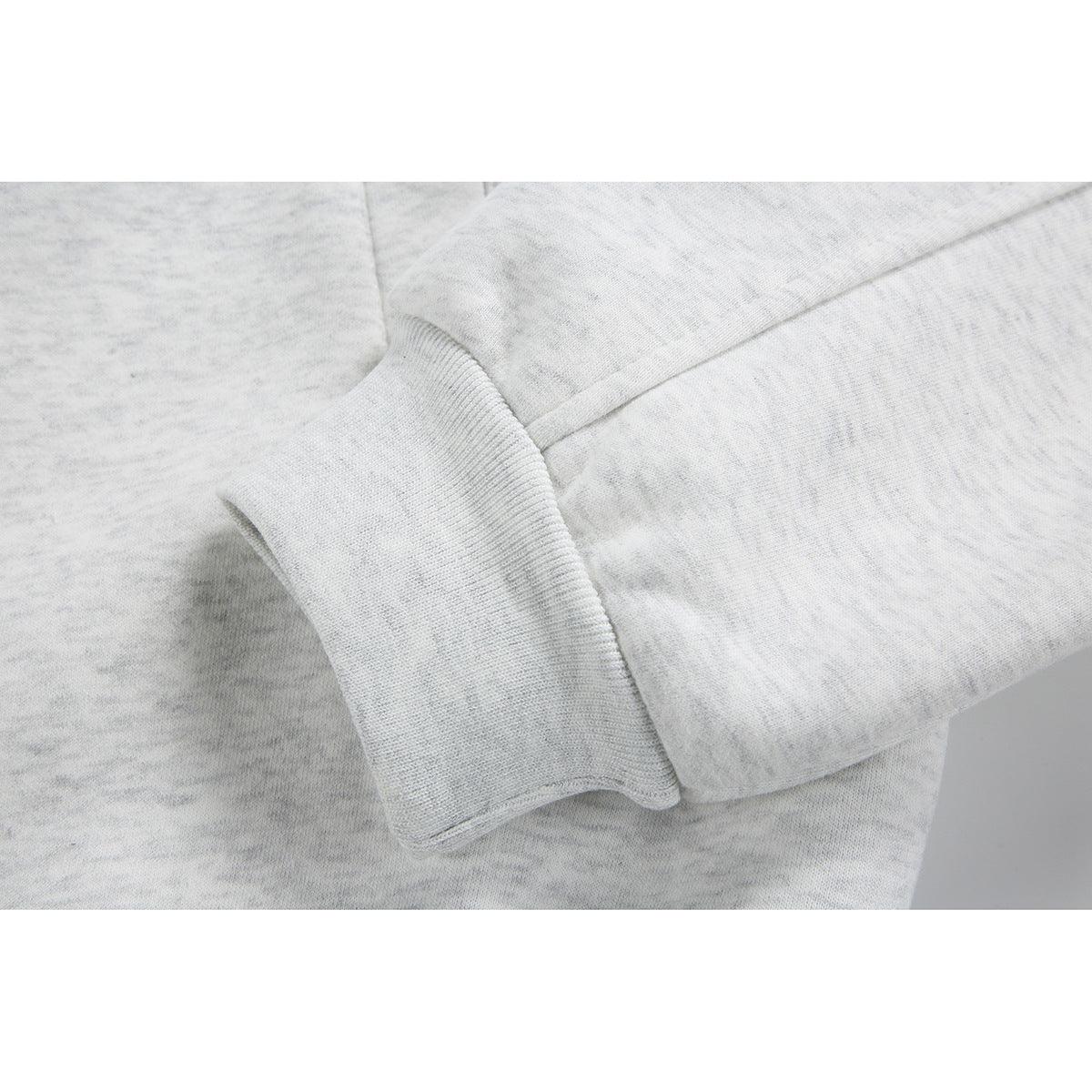 Close-up of a light gray jacket sleeve and ribbed cuff.