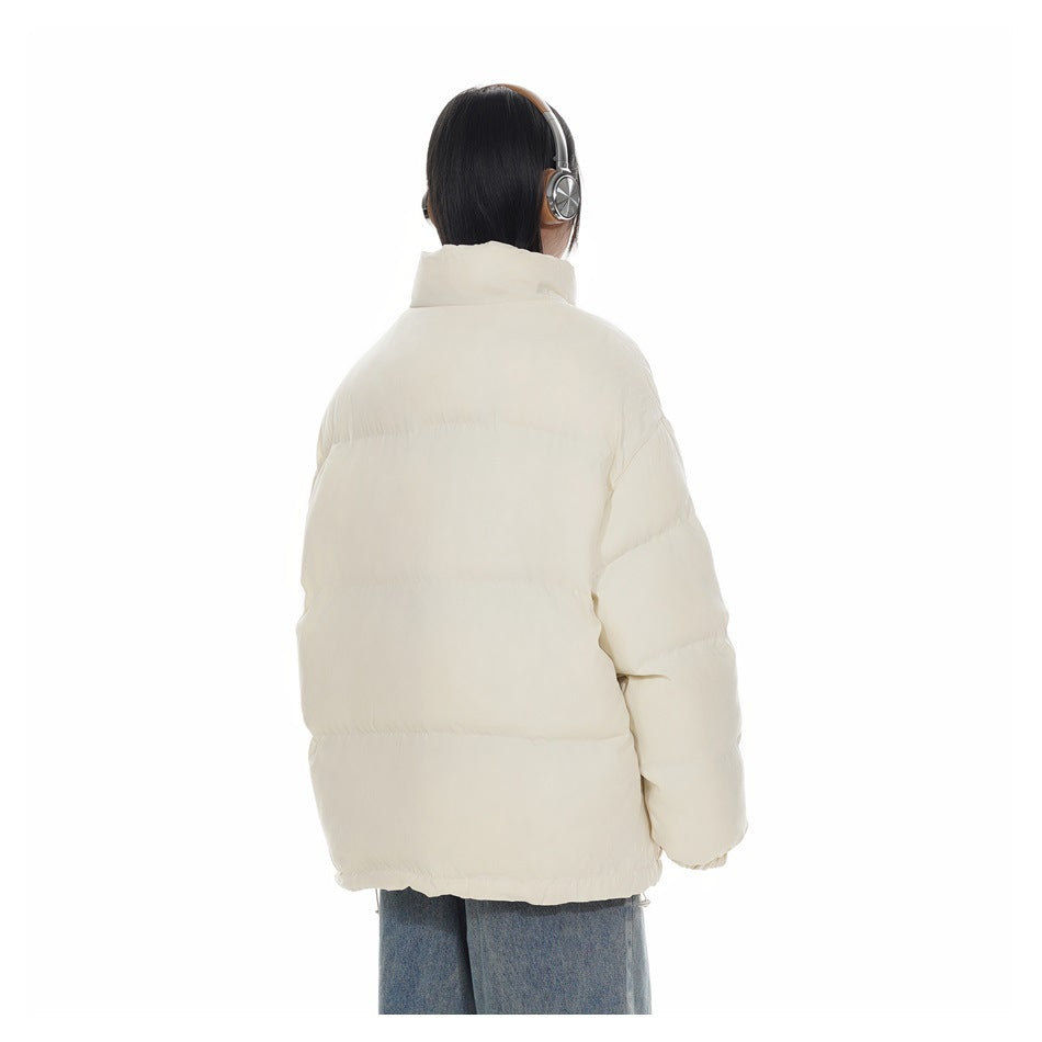 Rear view of a model wearing an ivory quilted puffer jacket with a raised collar.