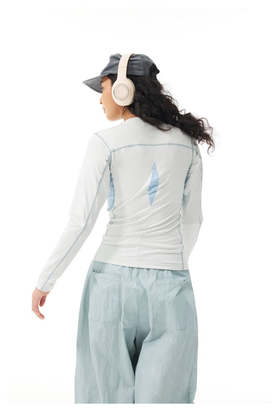 Back view of a white long-sleeve top with pale blue seam details and matching loose pale blue pants.