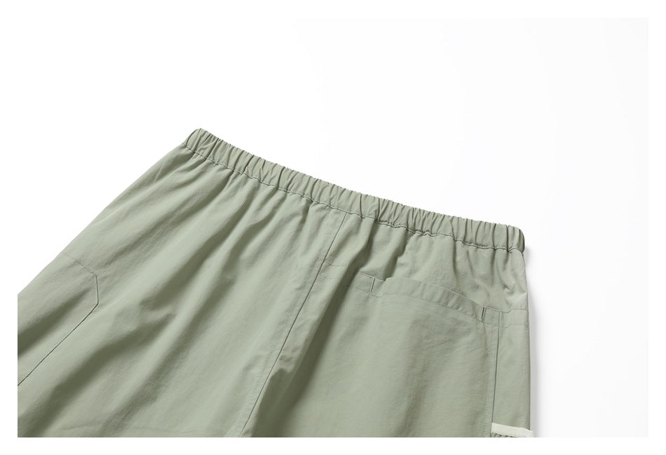 Cropped back view of sage-green pants with an elastic waistband and a large rear pocket.