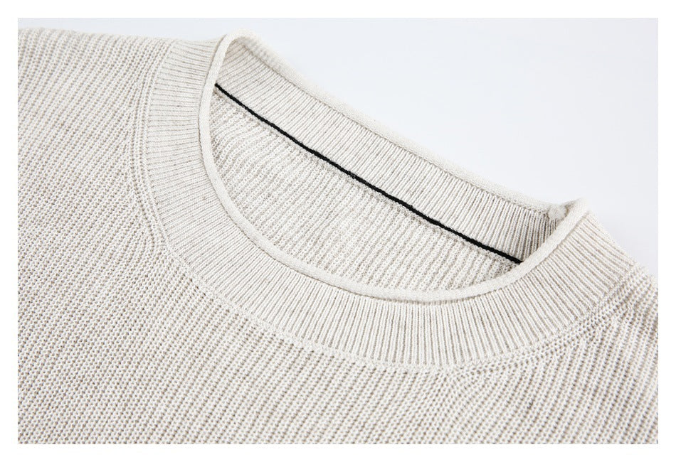 Close-up of the ivory knit crewneck, showing the ribbed collar and inner neckline seam.