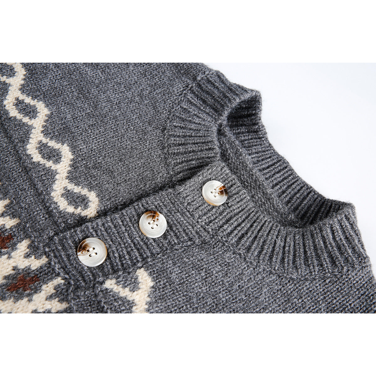 Close-up of a charcoal knit sweater’s ribbed button placket, three pale buttons, and cream patterned trim.