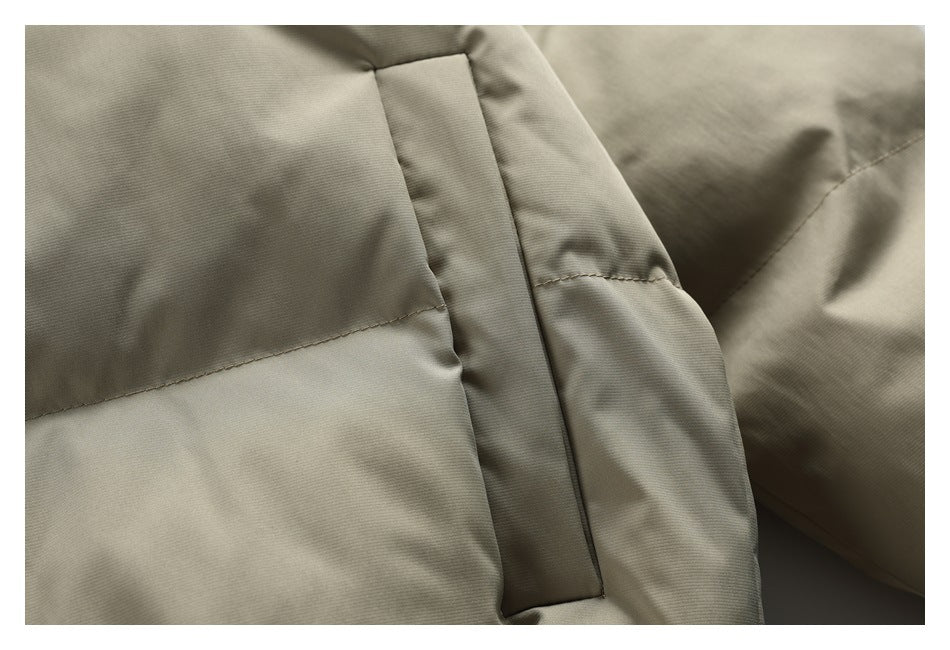 Close-up of the beige padded jacket’s front placket and horizontal stitched panels.