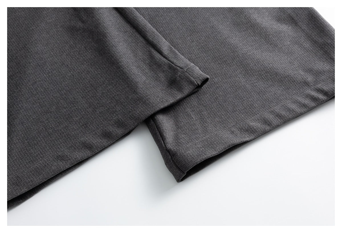 Close-up of the finished hems on charcoal gray trouser legs.