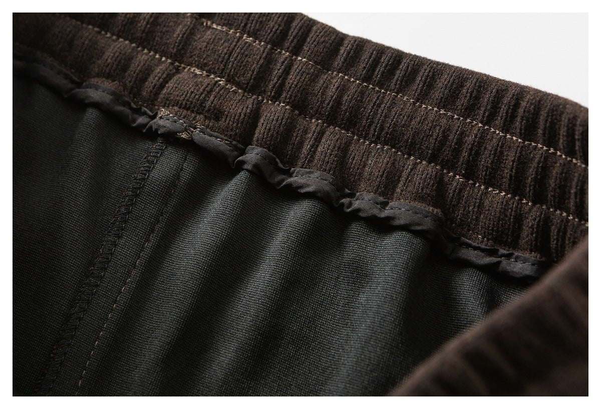 Close-up of a dark brown ribbed waistband and black interior lining with stitched trim.