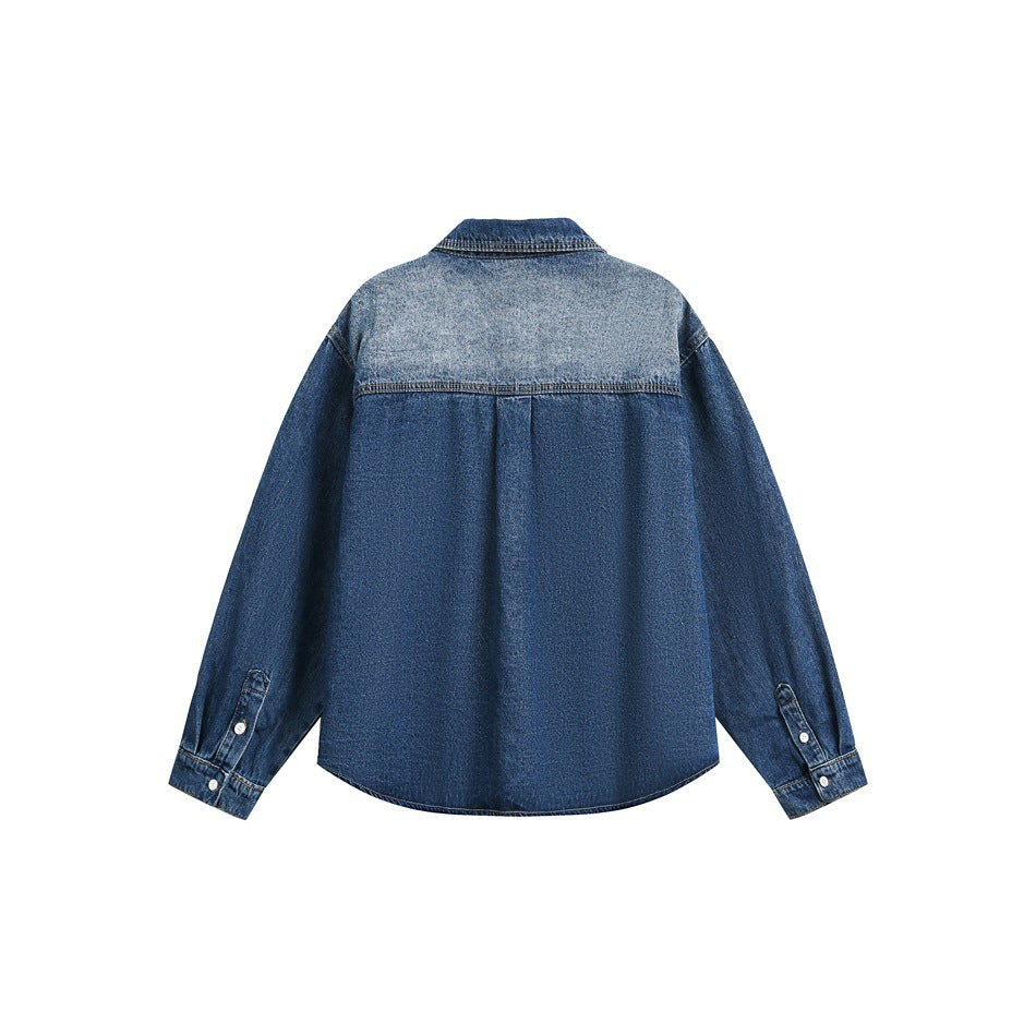 Back of a blue denim shirt with a light faded yoke, dark body, long sleeves, button cuffs, and curved hem, shown flat.