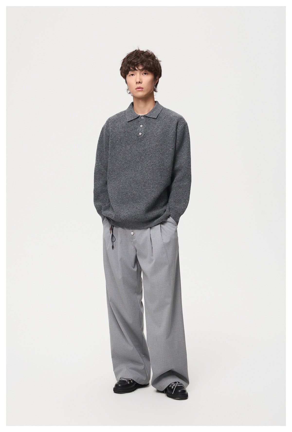 Full-length model wearing a charcoal gray knit polo with a collar and three-button placket.