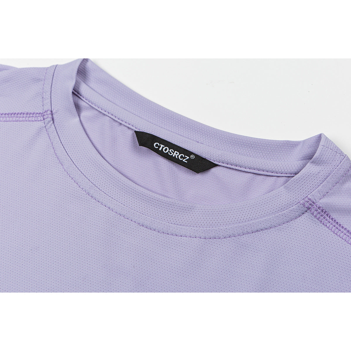 Close-up of a lavender T-shirt's crew neck, stitching, and black woven neck label.