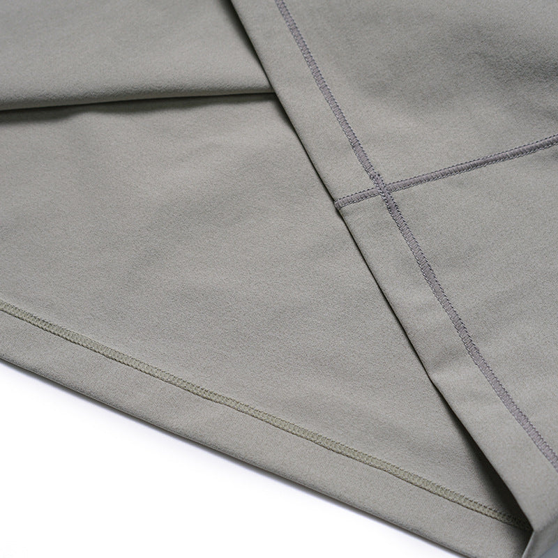 Close-up of a gray garment with intersecting overlock seams and a folded hem.