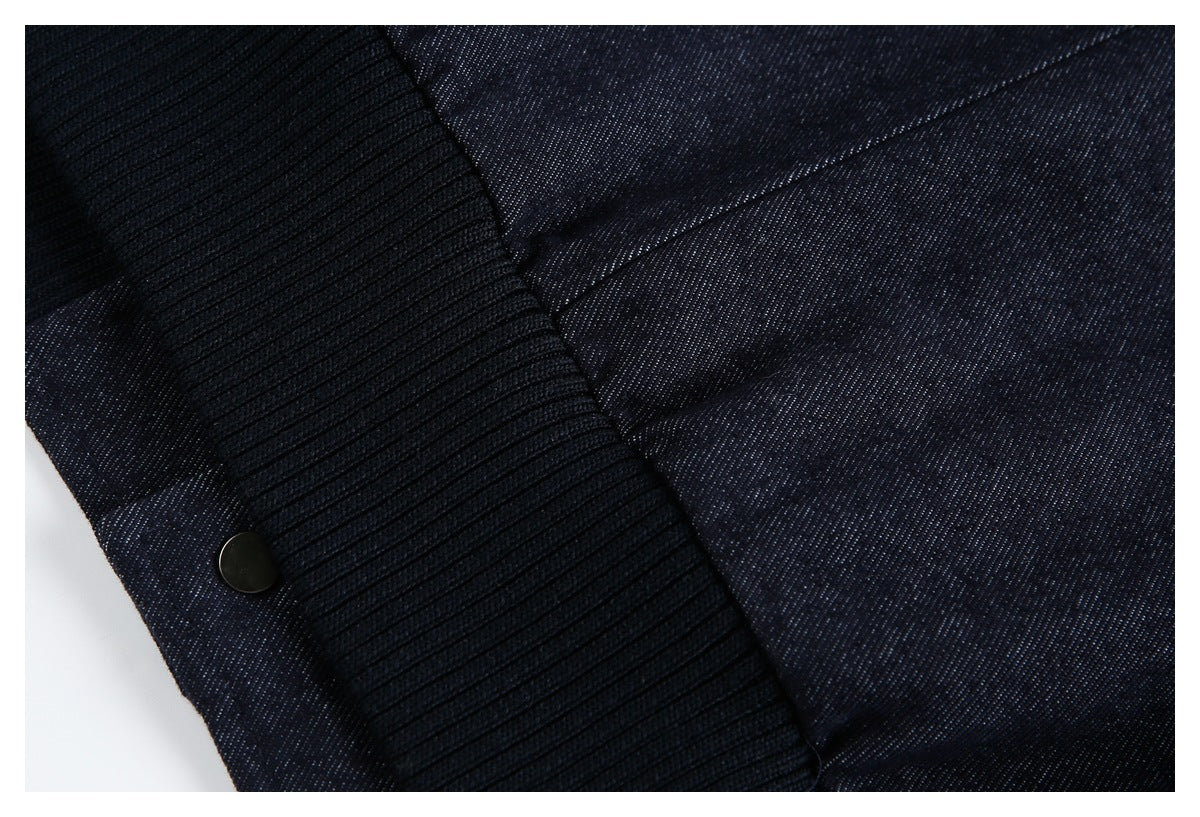 Close-up of a dark indigo garment showing a black rib-knit cuff and a dark snap.