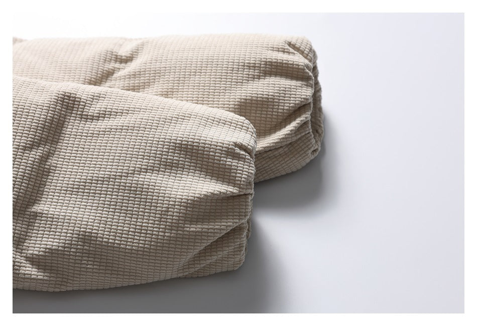Close-up of a beige textured jacket sleeve and cuff laid flat.