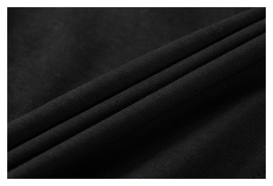 Close-up of black fabric with fine ribbed texture and soft folds.