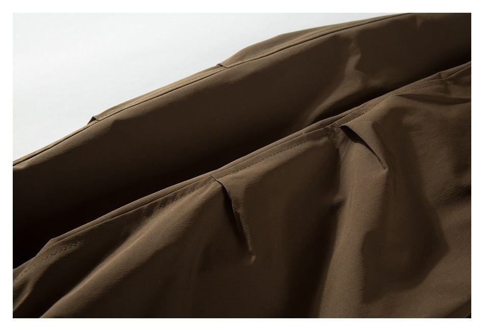 Close-up of stitched seams and folded fabric on a brown garment.