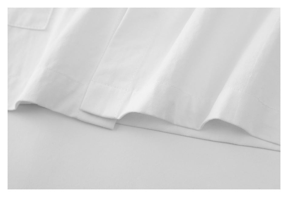 Close-up of a white garment hem with stitched edges and overlapping fabric layers.